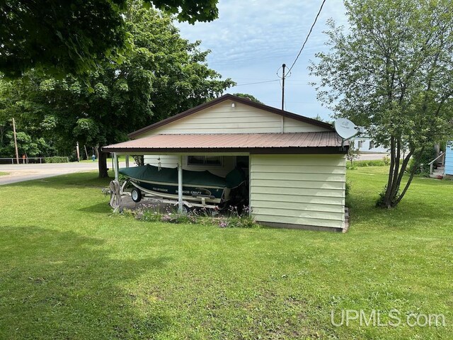 view of shed / structure featuring a carport and a lawn