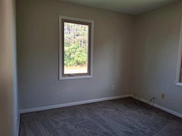 empty room featuring dark carpet