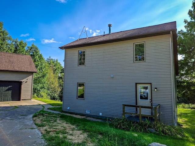 view of side of home featuring a garage and an outdoor structure