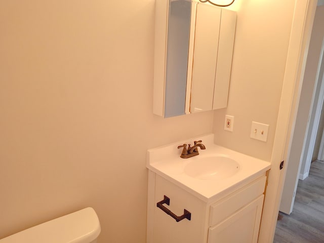 bathroom with vanity, hardwood / wood-style flooring, and toilet