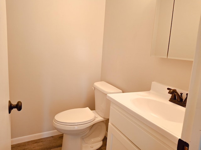 bathroom with hardwood / wood-style flooring, vanity, and toilet