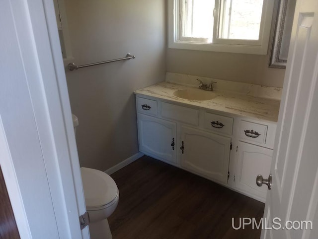 bathroom with hardwood / wood-style floors, vanity, and toilet