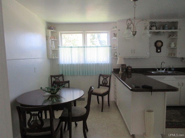 kitchen featuring white cabinetry, light tile patterned floors, pendant lighting, sink, and kitchen peninsula