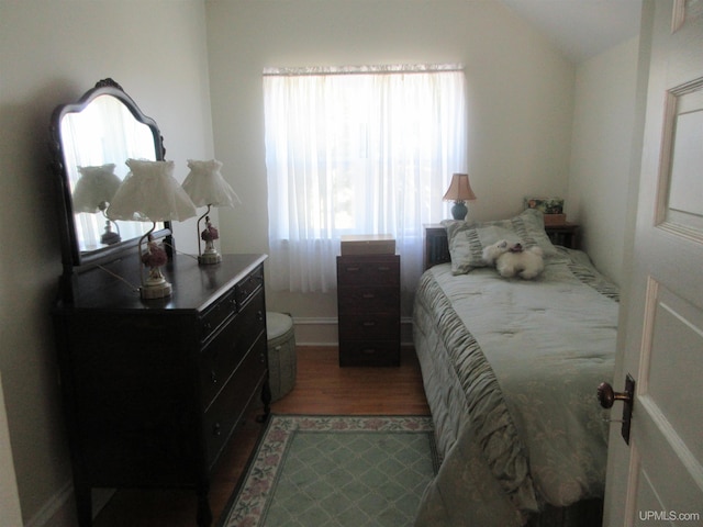 bedroom with wood-type flooring and lofted ceiling