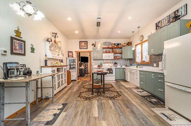 kitchen with a kitchen breakfast bar, dark hardwood / wood-style flooring, white appliances, and an inviting chandelier