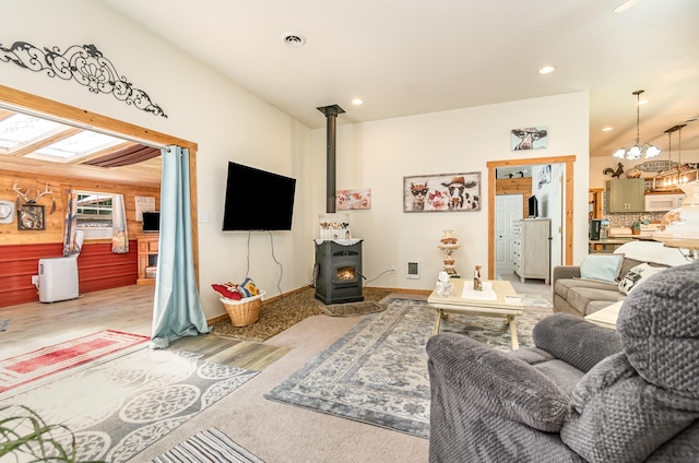 living room featuring a wood stove and a notable chandelier