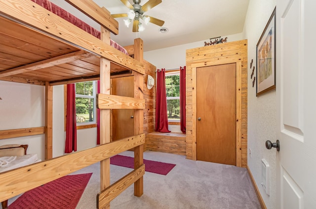 bedroom with multiple windows, ceiling fan, carpet floors, and wood ceiling