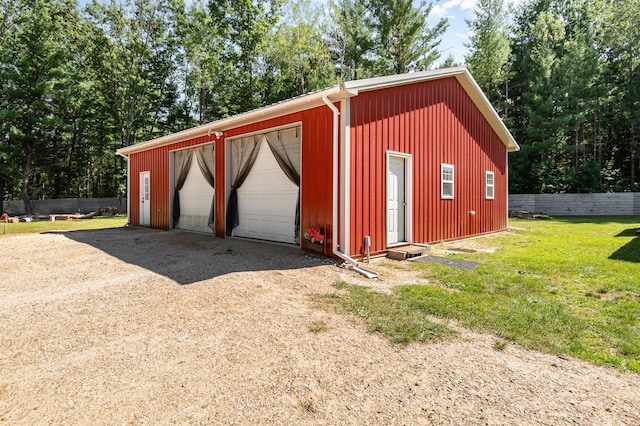 view of outdoor structure with a garage and a lawn