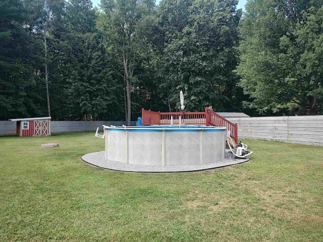 view of yard featuring a fenced in pool and a storage shed