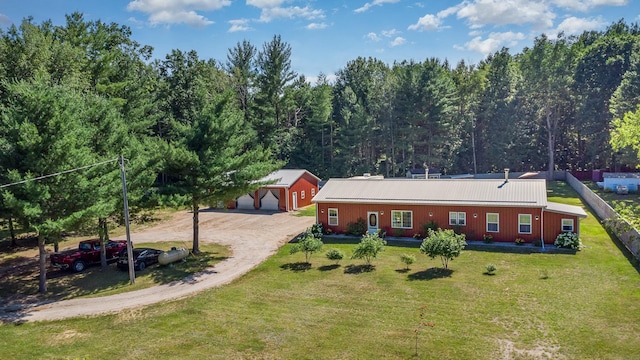 back of house with a lawn, a garage, and an outbuilding