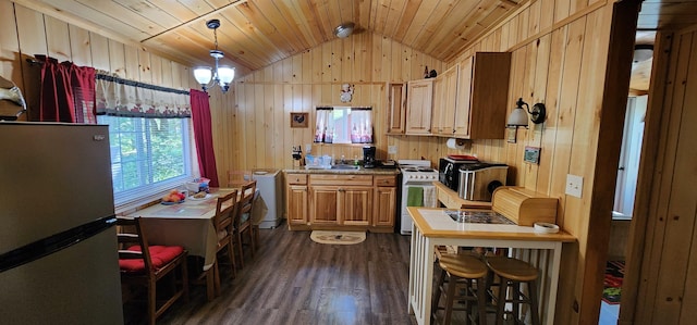 kitchen featuring white gas stove, vaulted ceiling, stainless steel fridge, decorative light fixtures, and dark hardwood / wood-style flooring