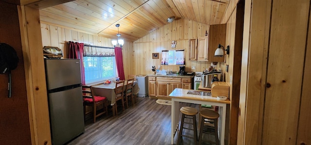 kitchen with dark wood-type flooring, hanging light fixtures, vaulted ceiling, stainless steel fridge, and wood ceiling