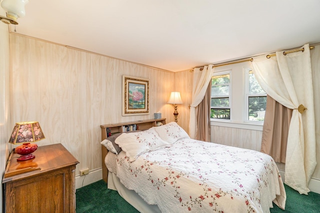 bedroom featuring wooden walls and dark carpet