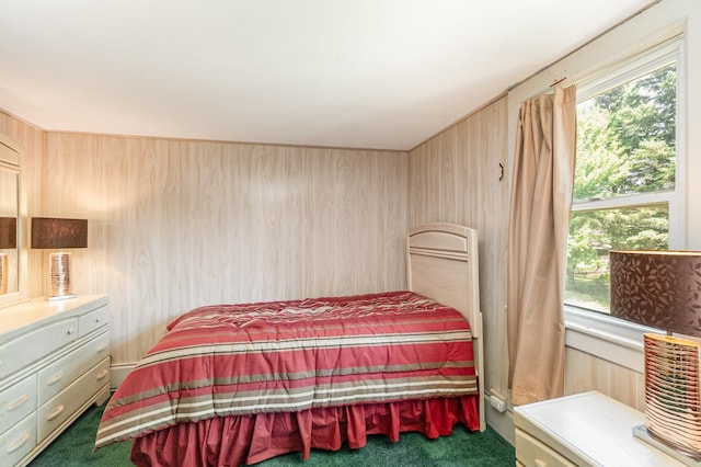 bedroom with wooden walls and dark colored carpet