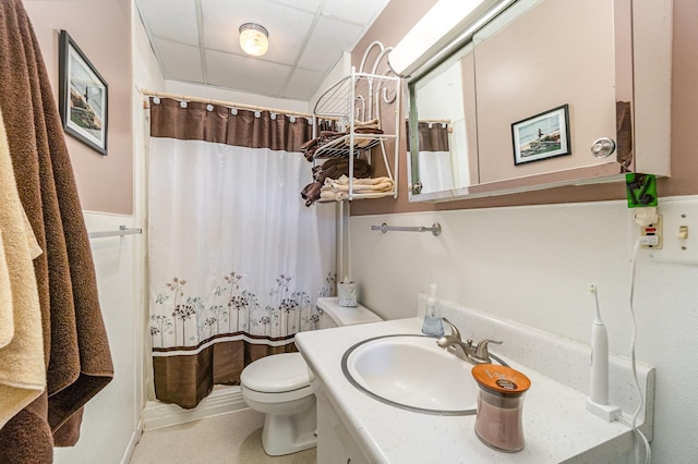 bathroom with a paneled ceiling, vanity, toilet, and a shower with curtain