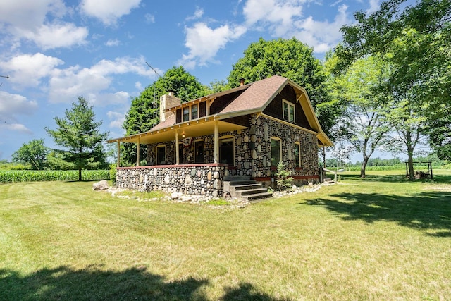 rear view of house with a porch and a lawn