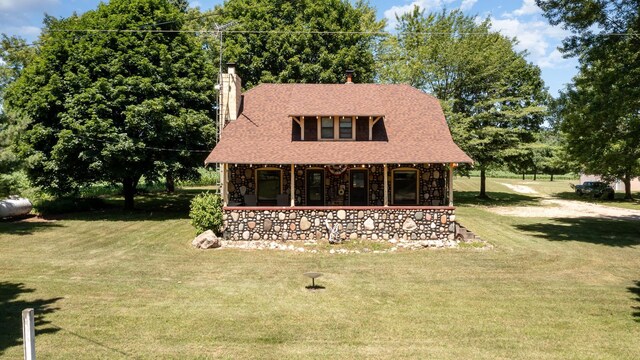 view of side of property with a porch and a yard