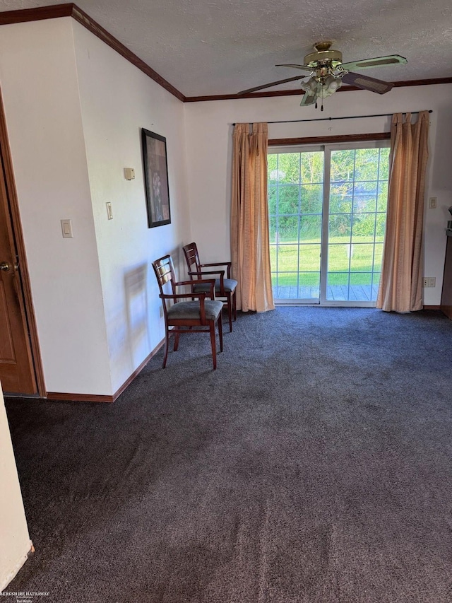 sitting room with a textured ceiling, ornamental molding, dark colored carpet, and ceiling fan