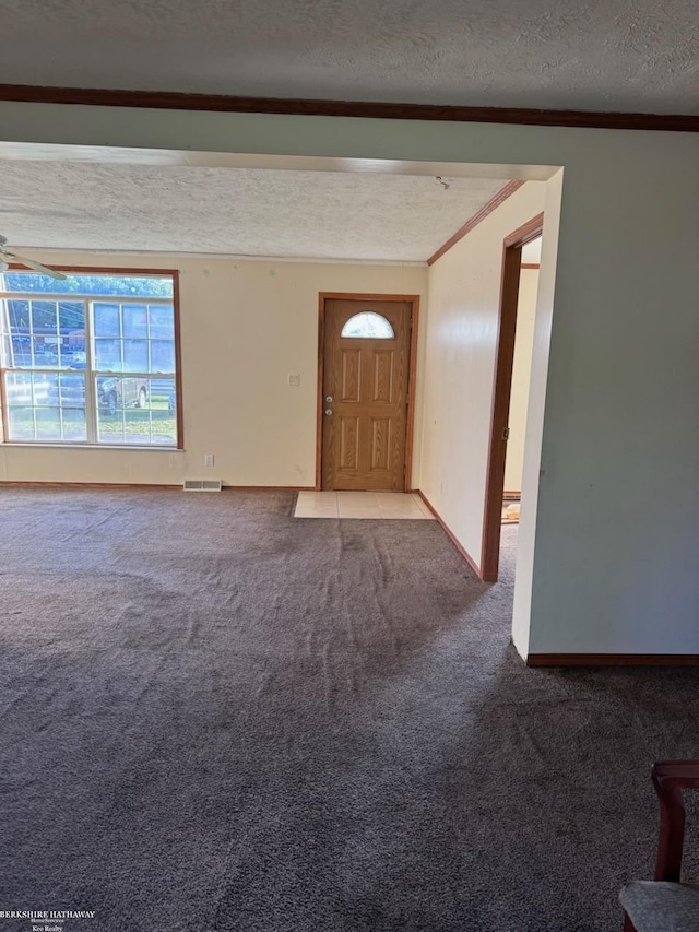 interior space with carpet flooring, crown molding, and a textured ceiling