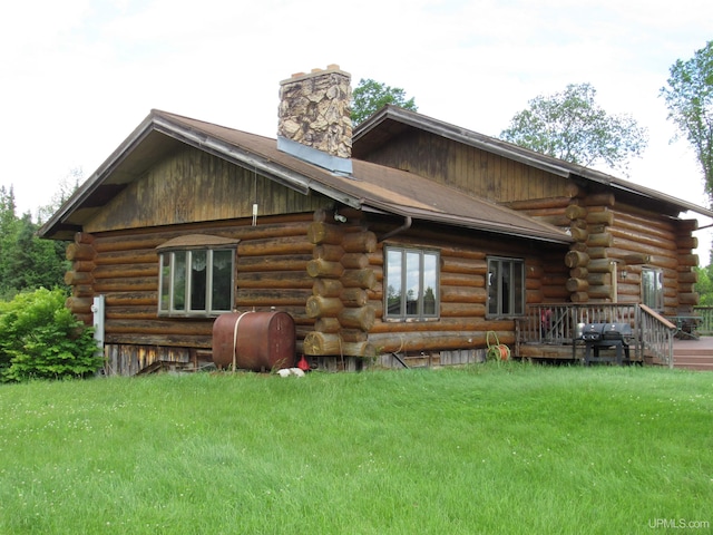 back of house featuring a lawn and a wooden deck