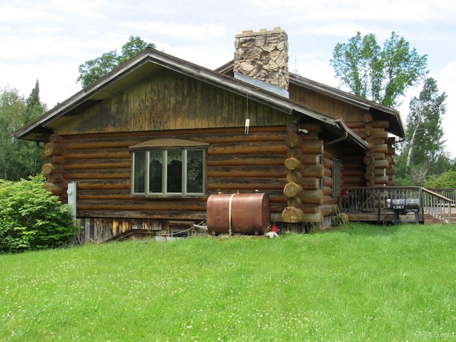 view of side of property featuring a lawn and a wooden deck