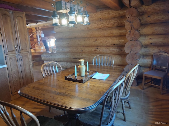 dining area with beamed ceiling, wood-type flooring, and log walls