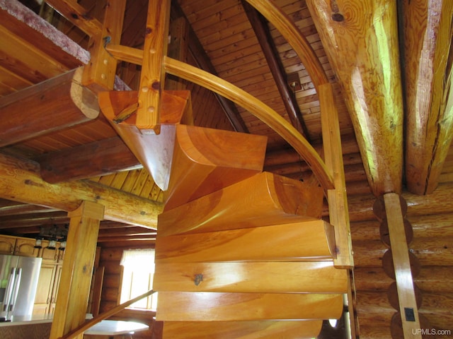 interior space with lofted ceiling with beams, wood ceiling, and log walls