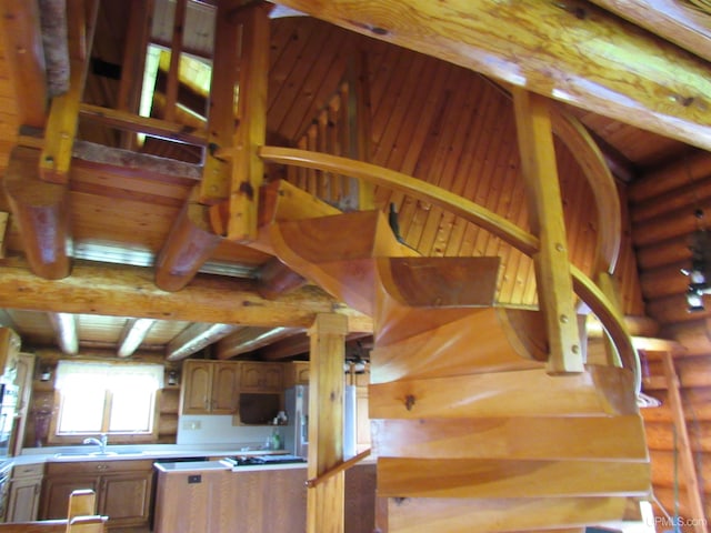 stairs featuring sink, vaulted ceiling, and log walls