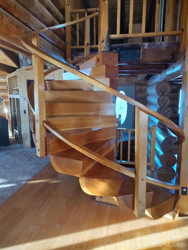 staircase featuring wood-type flooring and log walls