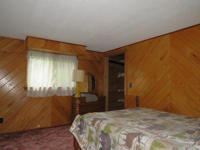 carpeted bedroom featuring wood walls