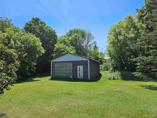 view of yard featuring a garage and an outbuilding