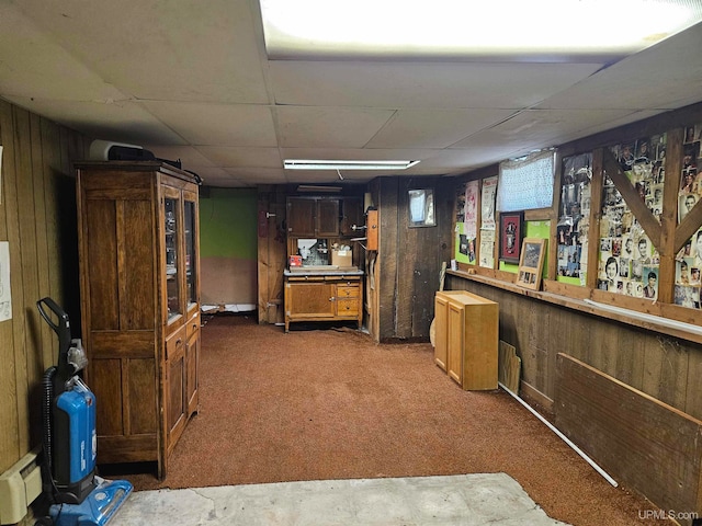 bar with wooden walls, carpet floors, and a paneled ceiling