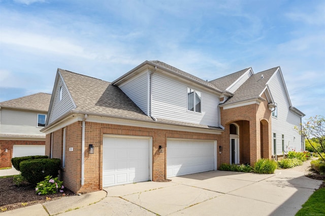 view of front of property with a shingled roof, brick siding, driveway, and a garage