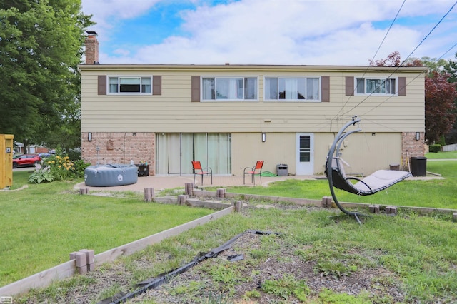 rear view of property with a lawn and a patio area