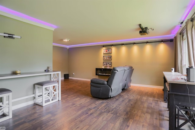 home theater with baseboards, ornamental molding, and wood finished floors