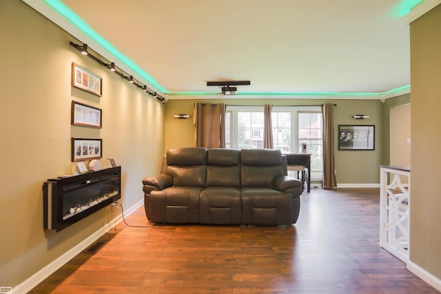 living room with baseboards, dark wood finished floors, and ornamental molding