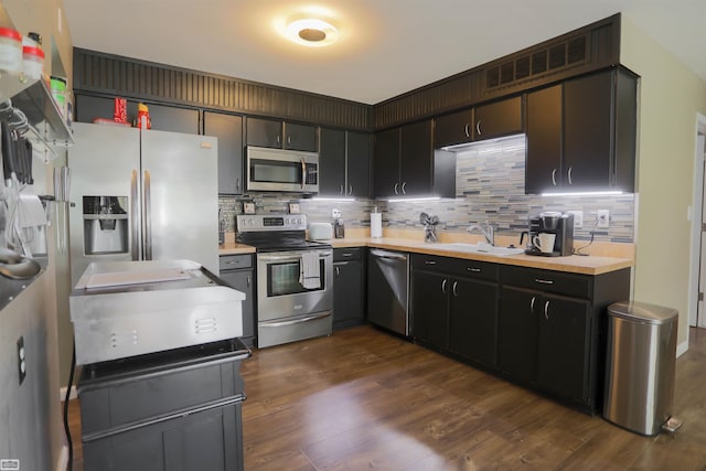 kitchen featuring sink, dark wood-type flooring, stainless steel appliances, and backsplash