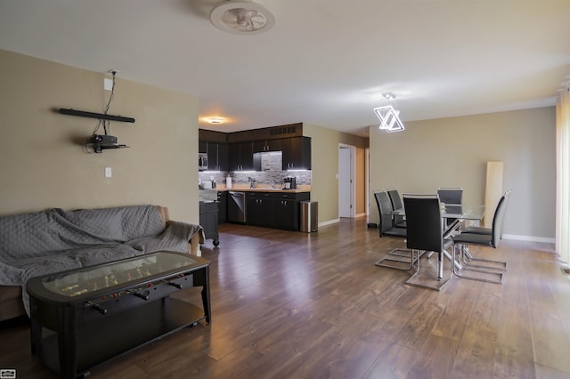 living room with baseboards and dark wood-style floors