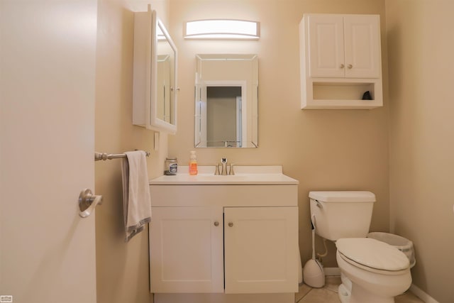 bathroom with vanity, baseboards, tile patterned flooring, and toilet