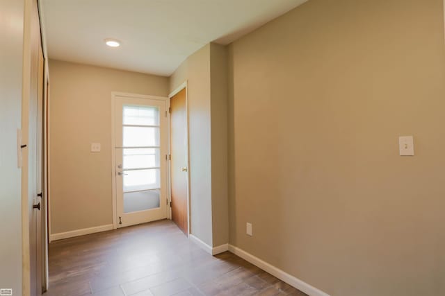doorway to outside with baseboards and wood finished floors