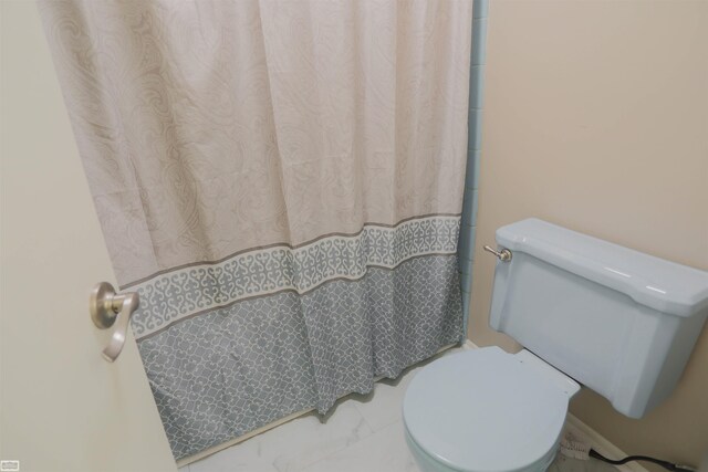 full bathroom featuring toilet, curtained shower, and marble finish floor