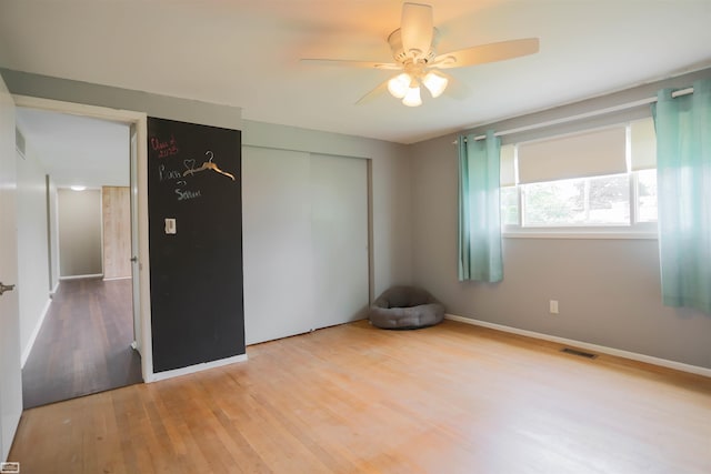 unfurnished bedroom featuring a closet, wood-type flooring, and ceiling fan