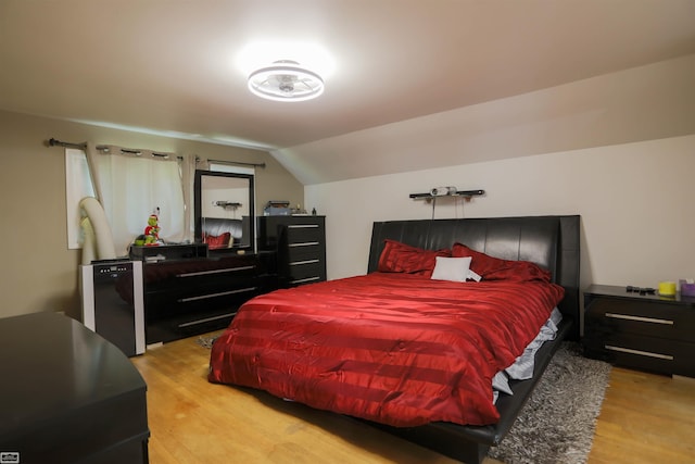bedroom with lofted ceiling and light wood-type flooring