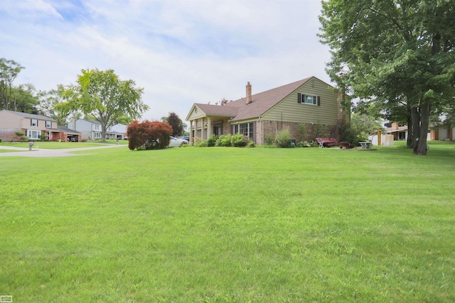 view of home's exterior with a lawn, brick siding, and a chimney