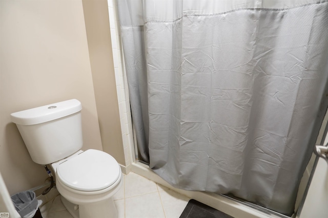 bathroom with tile patterned flooring, curtained shower, and toilet