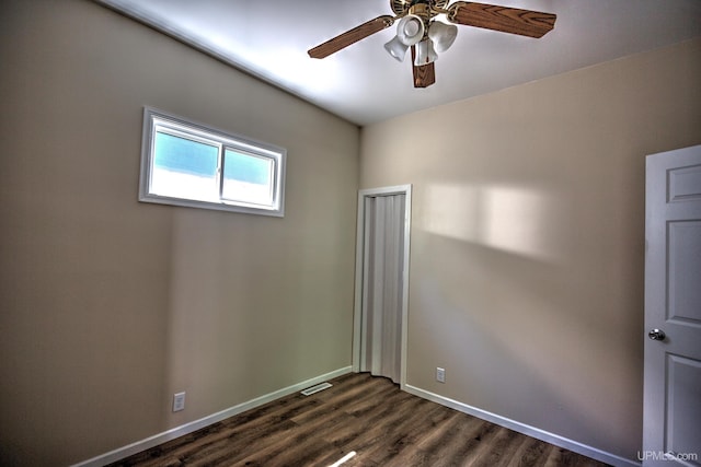 spare room with dark wood-type flooring and ceiling fan