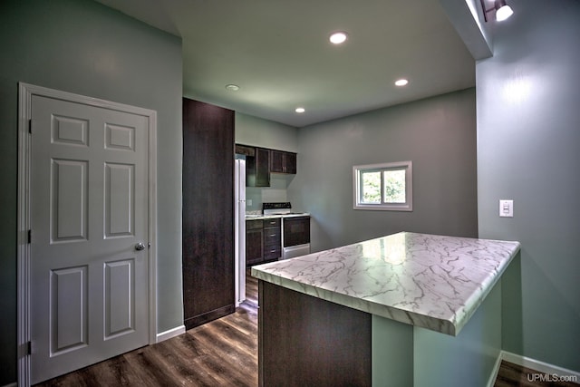 kitchen with light stone counters, kitchen peninsula, white range with electric stovetop, dark brown cabinetry, and dark hardwood / wood-style floors