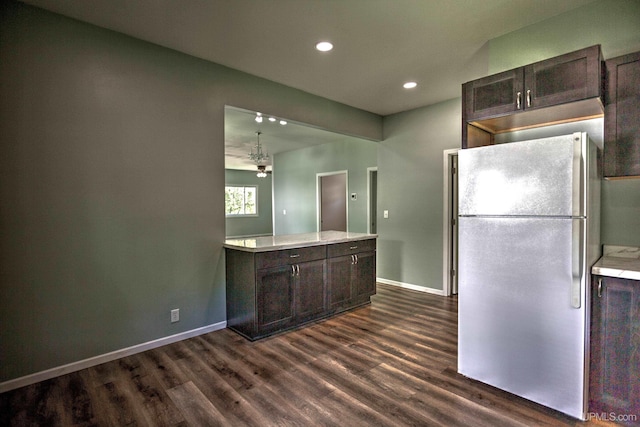 kitchen featuring dark brown cabinets, dark hardwood / wood-style flooring, hanging light fixtures, and white refrigerator