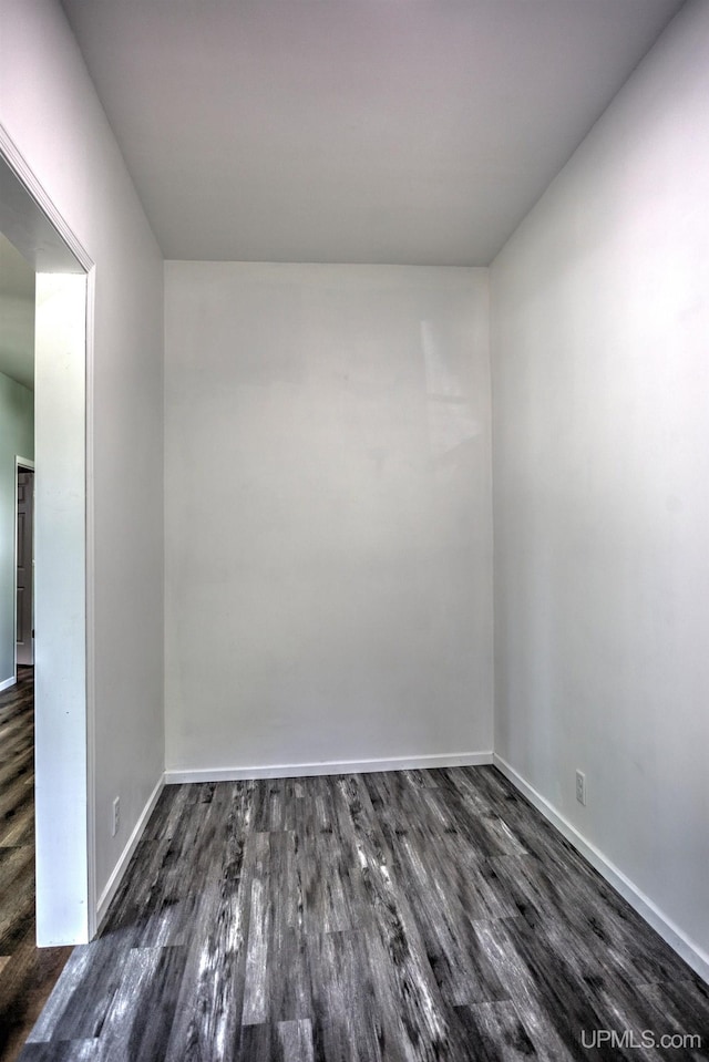 unfurnished room with dark wood-type flooring