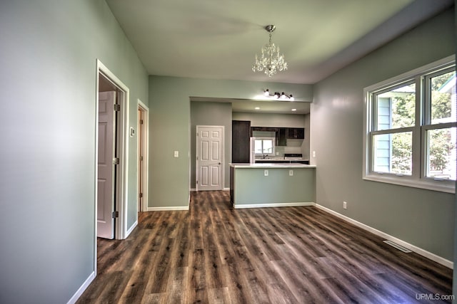 unfurnished living room featuring dark hardwood / wood-style flooring and a chandelier